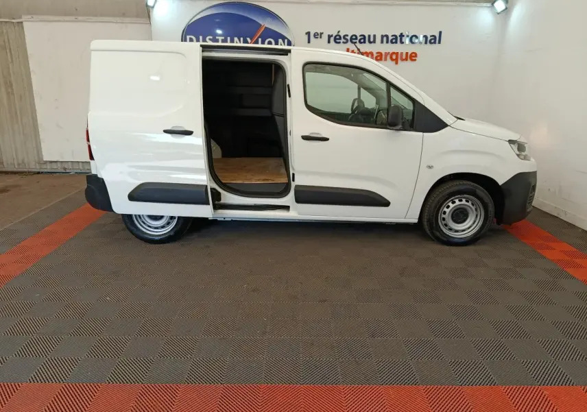 Vue latérale droite d’un utilitaire Citroën Berlingo blanc 2022 avec porte coulissante arrière ouverte, intérieur de chargement visible.