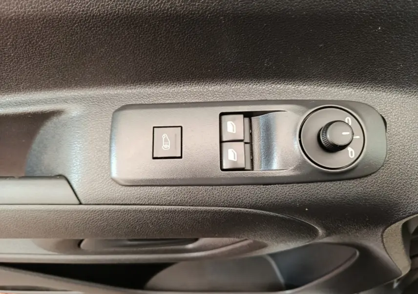 Gros plan sur les commandes de réglage des rétroviseurs et des vitres côté conducteur d'un Citroën Berlingo blanc 2022.