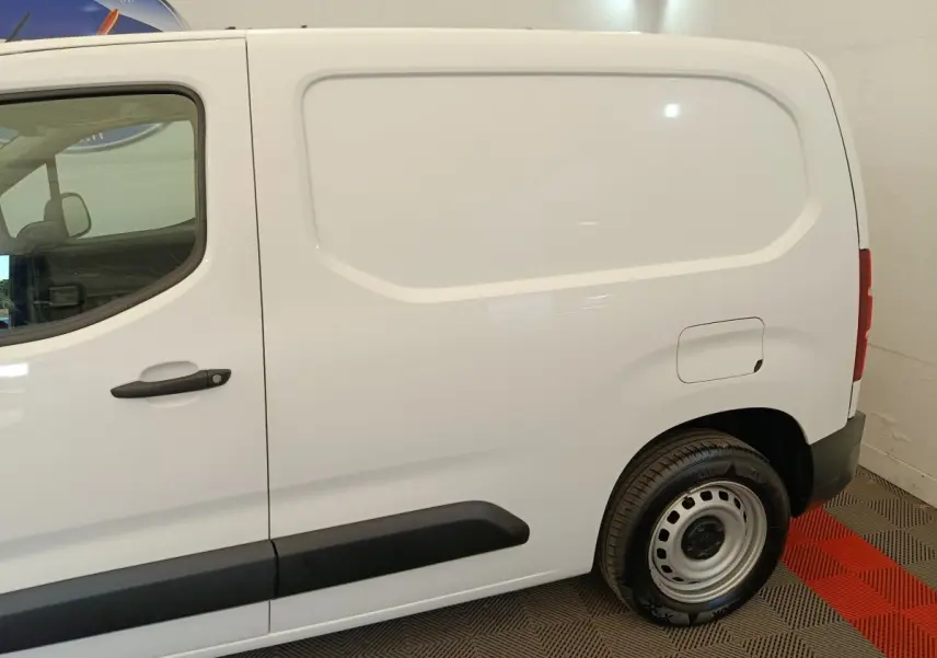 Vue latérale droite d’un utilitaire Citroën Berlingo blanc avec porte latérale pleine et jante acier.