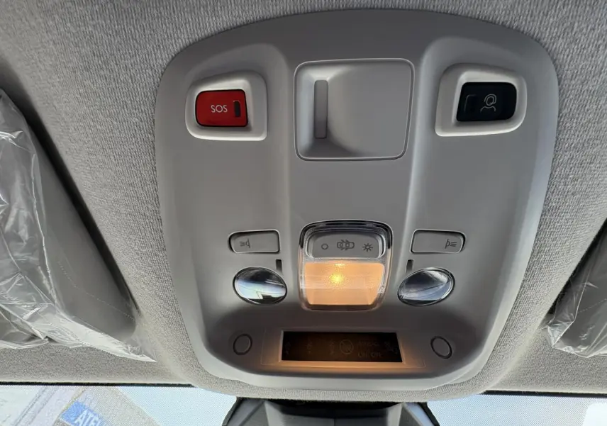 Plafonnier intérieur gris clair avec boutons SOS et éclairage, vue du toit avant d’un Opel Vivaro blanc 2024.