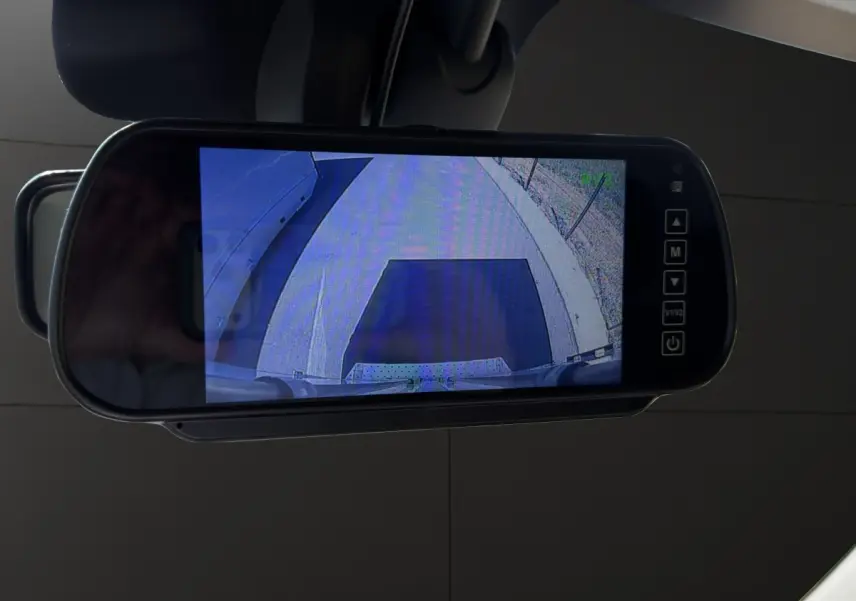 Écran de caméra de recul intégré au rétroviseur intérieur du Renault Master blanc, vue arrière du véhicule.