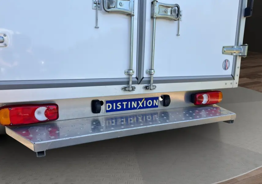 Vue rapprochée arrière du Renault Master blanc montrant les portes arrière fermées et le pare-chocs métallique avec feux intégrés.