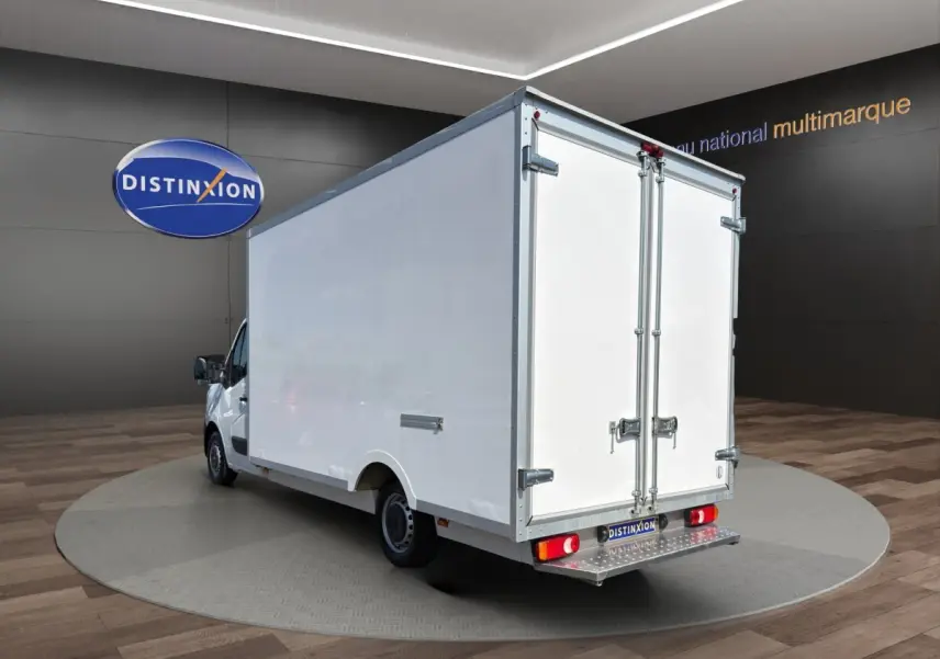 Renault Master blanc vu en 3/4 arrière droit, caisse fermée avec portes arrière battantes et marchepied métallique.