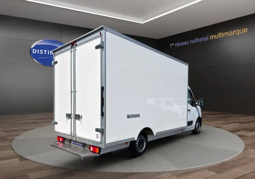 Renault Master blanc vu en 3/4 arrière droit, caisse fermée 20m3 avec portes arrière battantes et marchepied métallique.