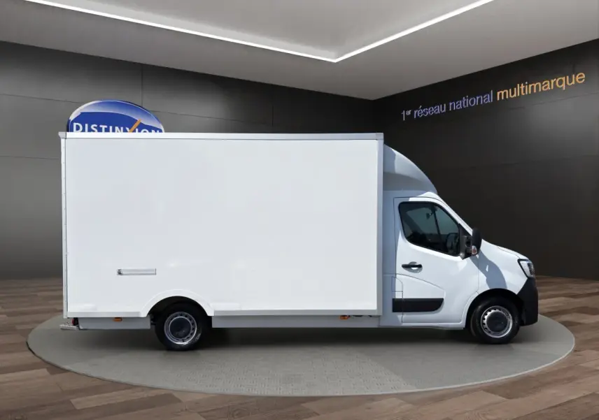 Vue de profil côté droit d’un utilitaire blanc Renault Master PHC TRAC 2024 avec caisse 20m3 dans un showroom.