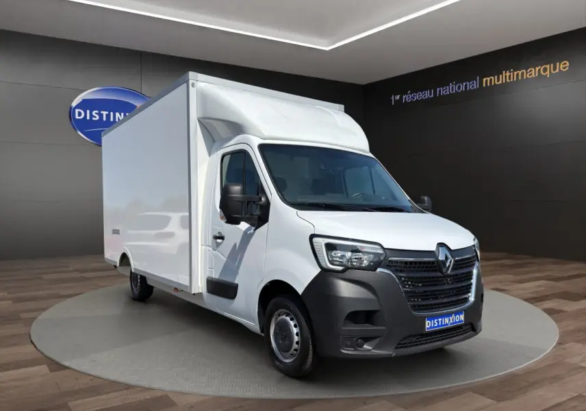 Renault Master blanc en 3/4 avant droit, avec caisse de livraison volumineuse et calandre noire distinctive.