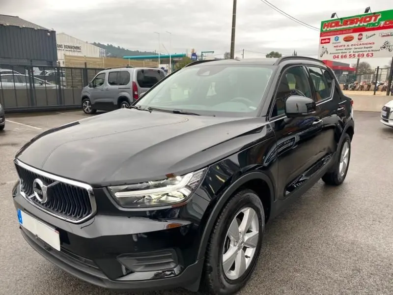 Volvo XC40 T3 noir solid vue 3/4 avant droit sur parking avec calandre chromée et jantes argentées.
