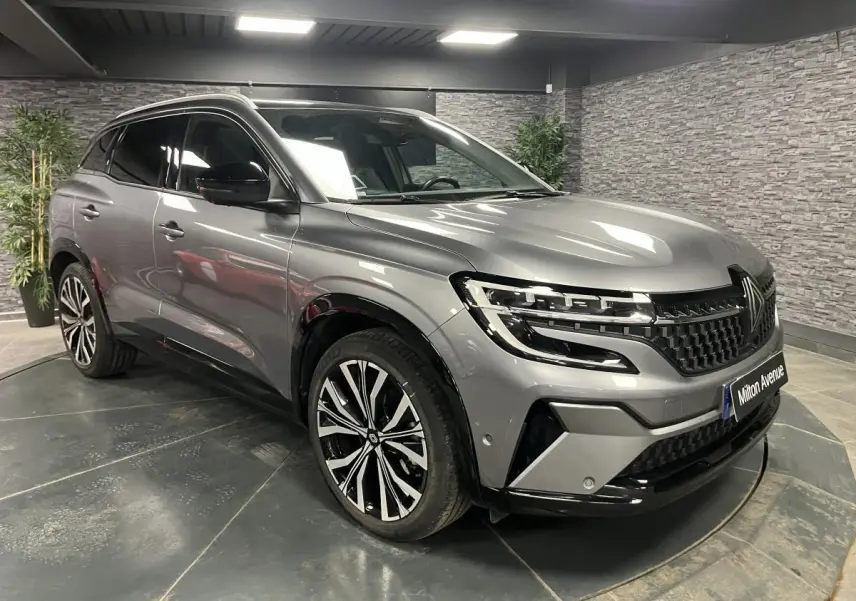 Renault Austral gris schiste en 3/4 avant droit, avec jantes alliage 20 pouces et toit panoramique fixe.