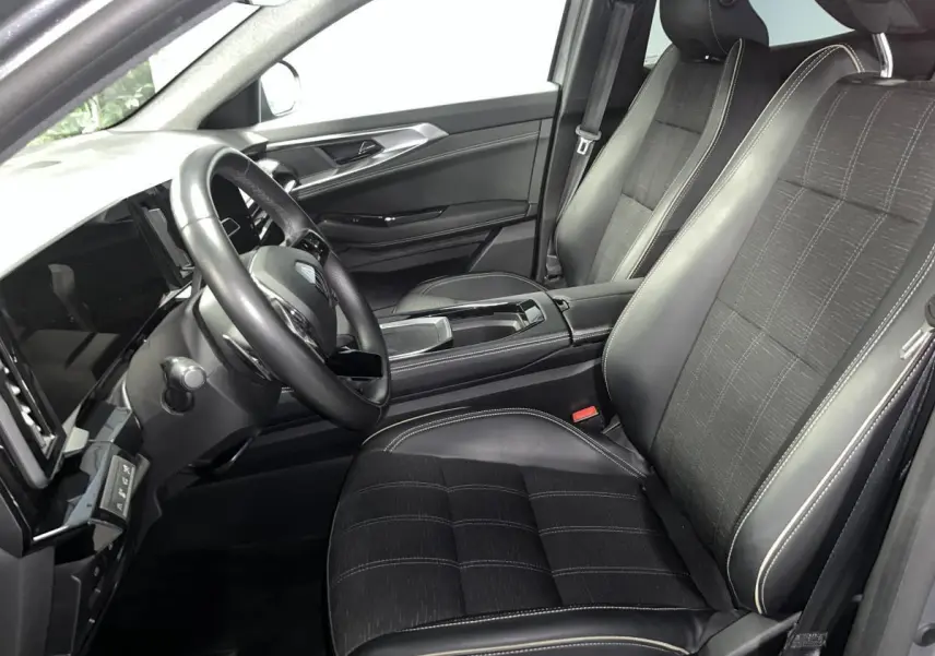 Vue intérieure côté conducteur du Renault Austral 2024, sièges en similicuir et tissu carbone foncé avec surpiqûres or.