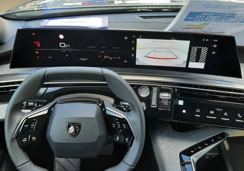 Vue intérieure du tableau de bord et volant Peugeot 5008 2025, avec écran numérique large et interface moderne.