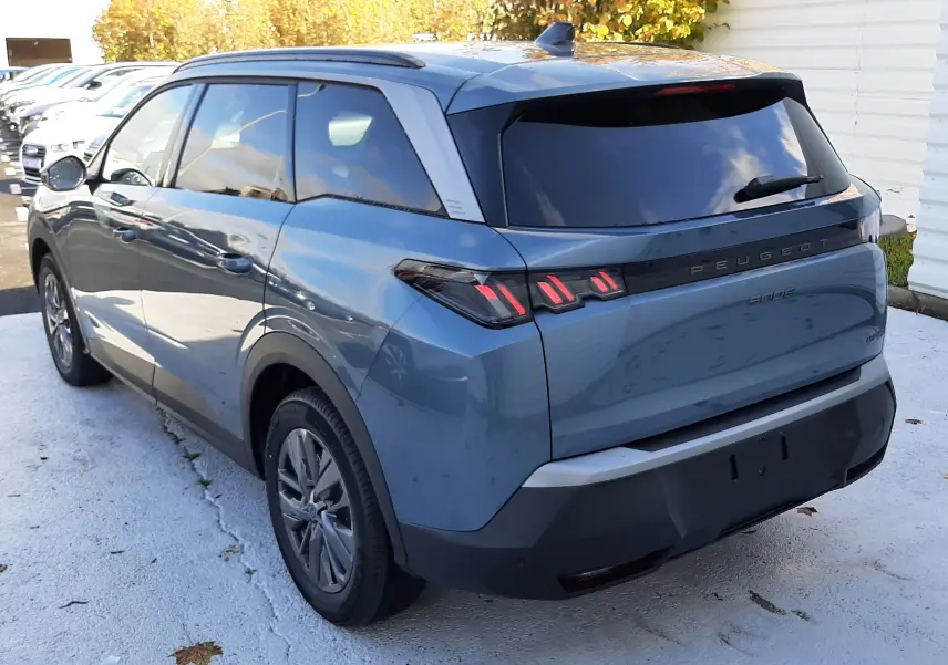 Vue 3/4 arrière droite d'un Peugeot 5008 bleu Ingaro 2025 avec feux arrière LED et vitres teintées