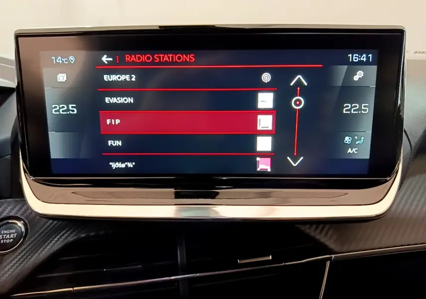Écran tactile central 10 pouces du tableau de bord du Peugeot 2008 noir, affichant les stations radio et la température.
