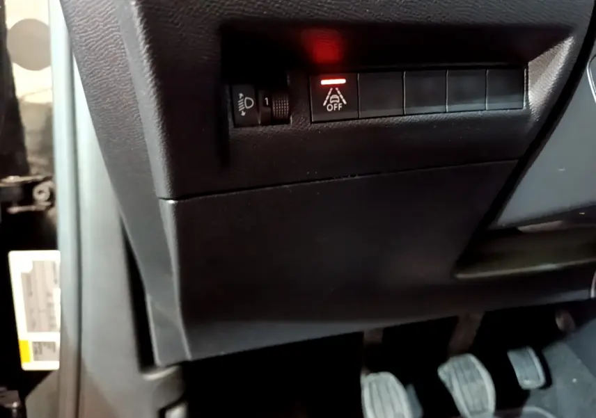 Gros plan sur les commandes noires côté gauche sous le tableau de bord du Peugeot 2008 PureTech 130 S&S Allure Business.