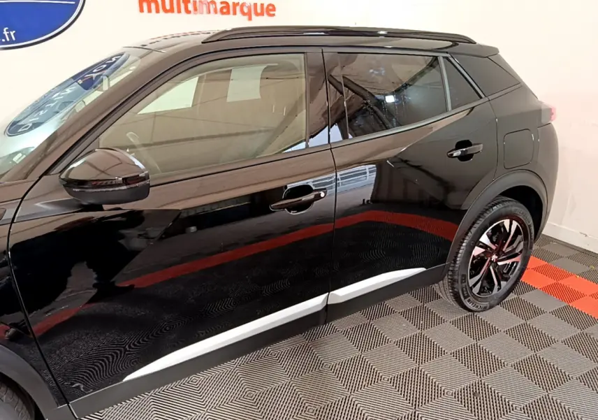 Profil côté gauche du Peugeot 2008 noir 2021 avec jantes alliage et rétroviseurs noirs brillants.