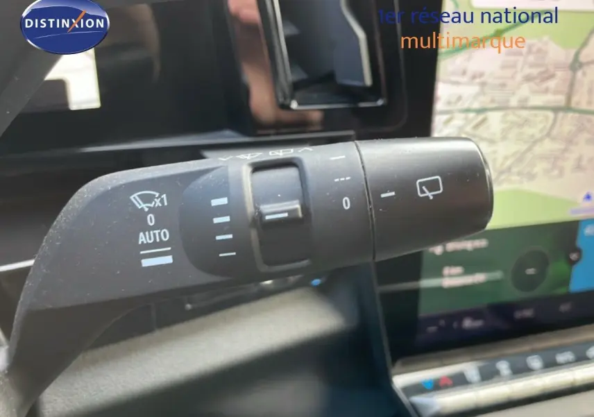Gros plan sur la commande d’essuie-glace du Renault Espace gris schiste, avec écran tactile et carte visible en arrière-plan.