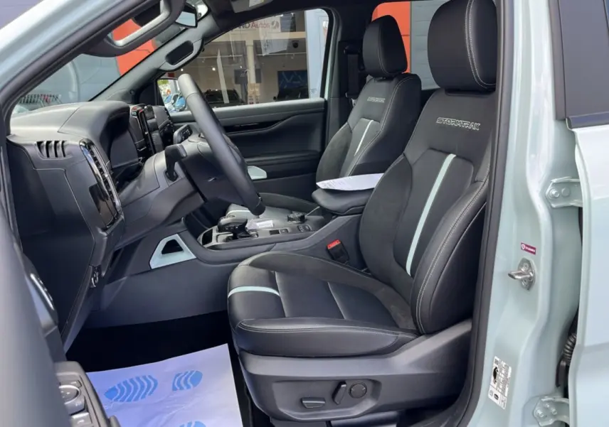 Intérieur avant droit du Ford Ranger gris zen 2026 avec sièges Stormtrak noirs et détails gris clair.