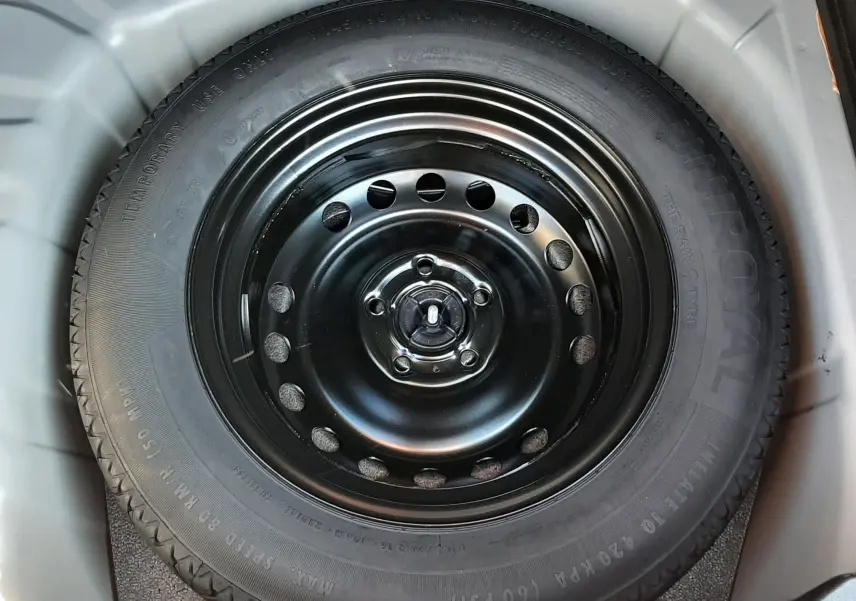 Gros plan sur la roue de secours noire dans le coffre du Renault Captur II gris Cassiopée 2025.