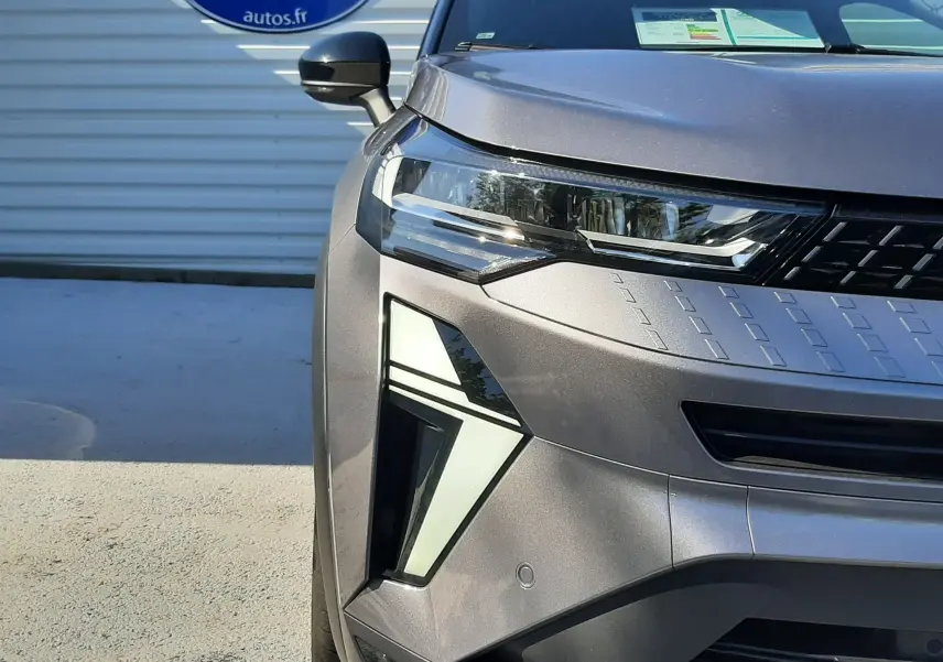 Vue avant droite du Renault Captur II gris Cassiopée 2025, mettant en valeur ses phares LED et la calandre moderne.