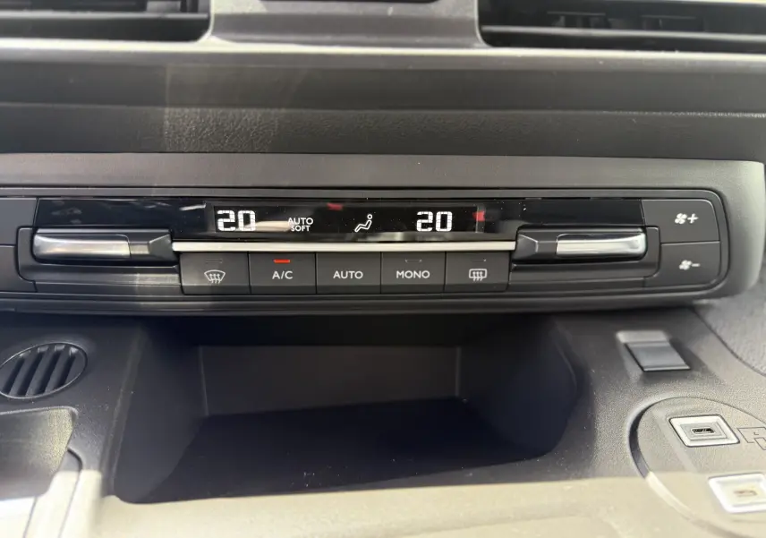 Gros plan sur la commande de climatisation digitale du Citroën Berlingo gris, affichant 20°C avec réglages automatiques.