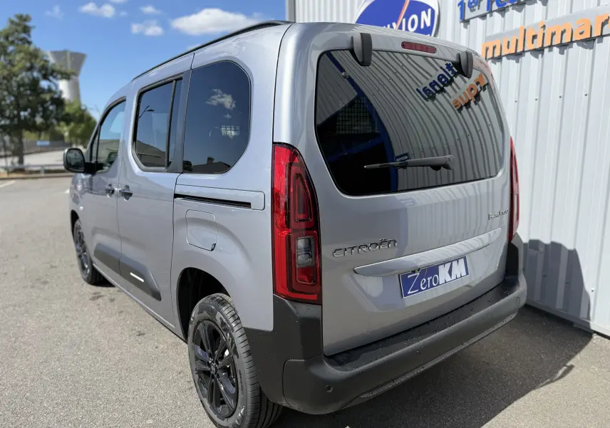 Vue 3/4 arrière droite d'un Citroën Berlingo gris Artense métallisé avec vitres teintées et jantes noires.