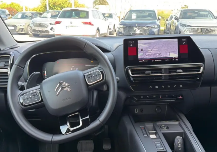 Vue intérieure avant du tableau de bord noir du Citroën C5 Aircross 2025 avec écran tactile et volant multifonction.