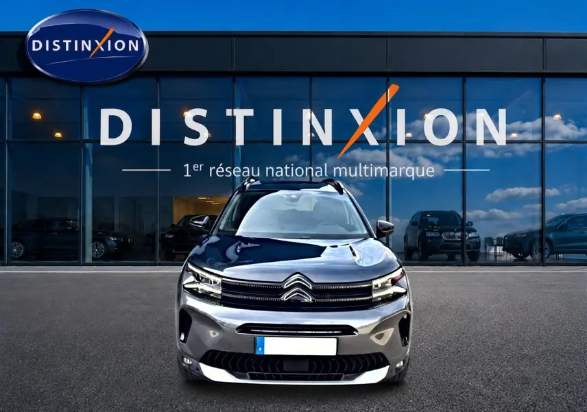 Vue frontale d'un Citroën C5 Aircross gris 2025 avec calandre distinctive et phares LED devant un showroom Distinxion.