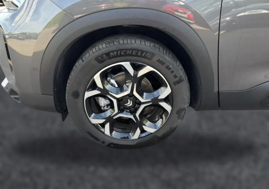 Gros plan sur la roue avant gauche du Citroën C5 Aircross gris 2025 avec jante alliage noire et argentée.
