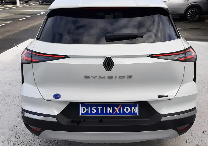 Vue arrière d'une Renault Symbioz blanc nacré, avec feux arrière LED fins et logo central noir brillant.