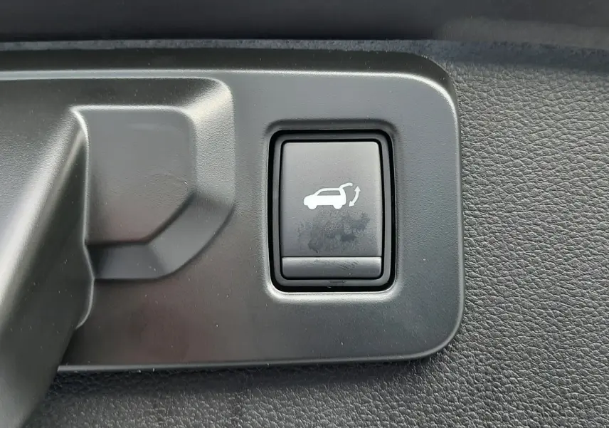 Bouton intérieur noir avec pictogramme d'ouverture de hayon sur Renault Symbioz E-Tech Full Hybrid 2025.