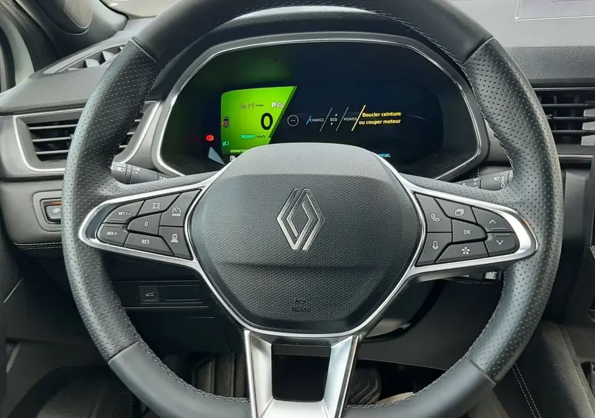 Vue rapprochée du volant noir de la Renault Symbioz E-Tech Full Hybrid 2025 avec tableau de bord numérique allumé.
