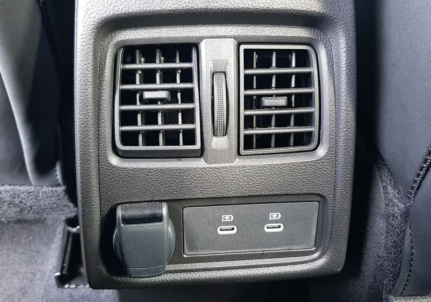 Vue rapprochée des aérateurs arrière et des ports USB-C noirs sur la console centrale du Renault Symbioz blanc nacré.