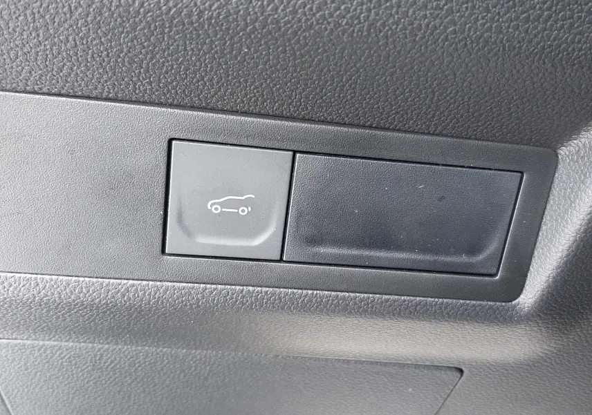 Bouton intérieur noir avec symbole d'ouverture du coffre sur Renault Symbioz E-Tech Full Hybrid 2025.