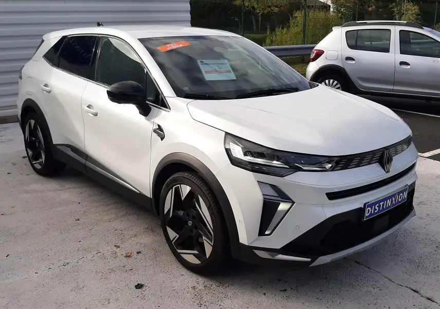 Renault Symbioz blanc nacré en 3/4 avant droit, avec jantes noires et détails noirs contrastants sur les rétroviseurs et bas de caisse.