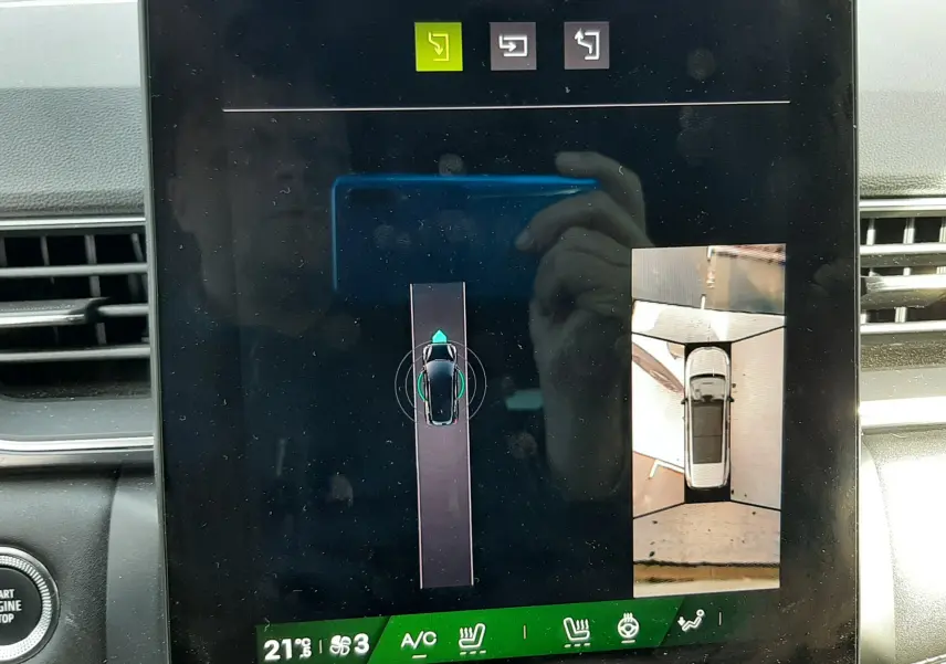 Écran tactile intérieur montrant la caméra 360° du Renault Symbioz blanc nacré, vue de dessus du véhicule en stationnement.