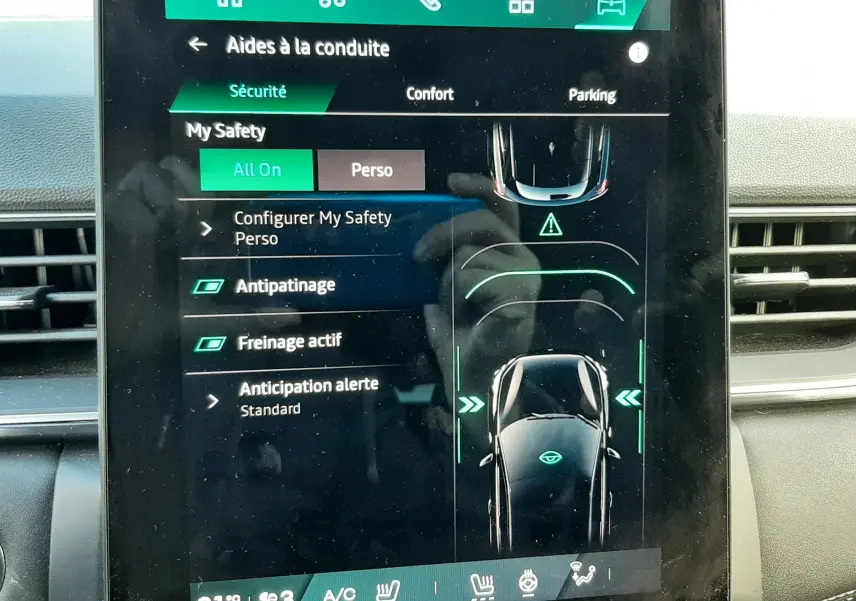 Écran tactile intérieur du Renault Symbioz blanc nacré, affichant les aides à la conduite et réglages de sécurité.