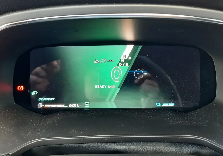 Vue rapprochée du tableau de bord numérique du Renault Symbioz blanc nacré, affichant la vitesse à zéro et l'autonomie de 620 km.