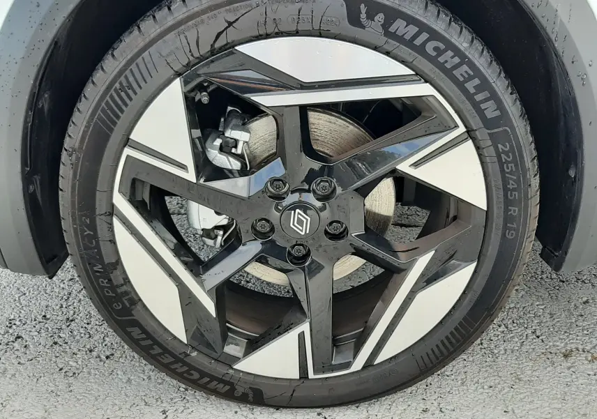 Gros plan sur la jante bi-ton noire et argent de 19 pouces avec logo Renault, montée sur pneu Michelin 225/45 R19.