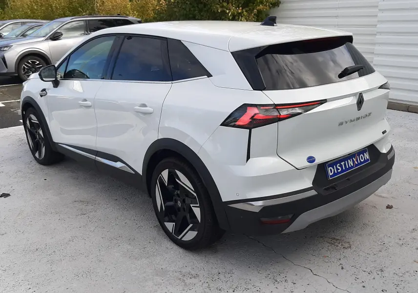 Renault Symbioz blanc nacré en 3/4 arrière droit, avec feux arrière LED distinctifs et jantes bicolores.