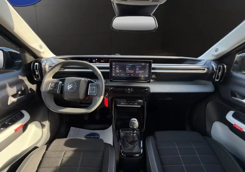 Vue intérieure avant de la Citroën C3 Turbo 100 BVM6 MAX 2025, volant cuir, écran tactile 10,25 pouces, sièges noirs.