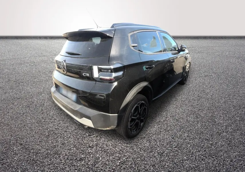 Vue 3/4 arrière droite d'une Citroën C3 Turbo 100 BVM6 MAX noire avec jantes noires et toit surélevé.