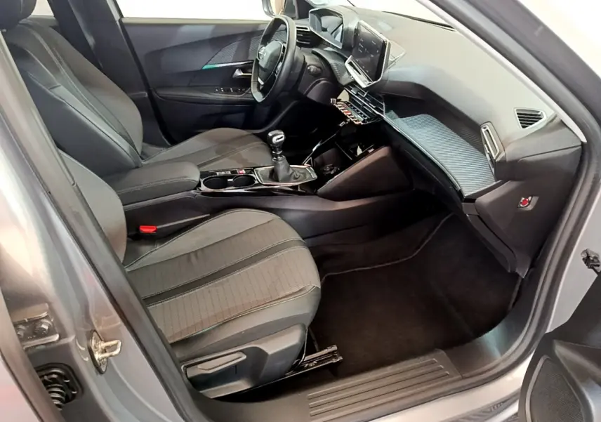 Intérieur côté conducteur d'une Peugeot 2008 gris clair, avec tableau de bord moderne et écran tactile central.