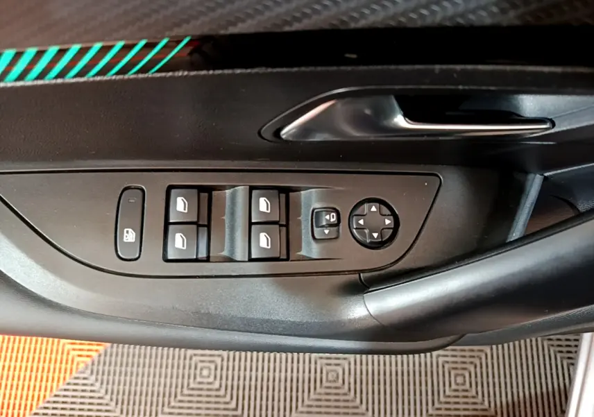 Panneau de porte côté conducteur du Peugeot 2008 gris clair, avec commandes électriques des vitres et rétroviseurs.