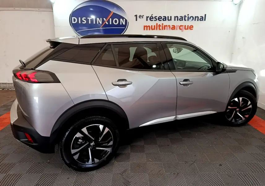 Peugeot 2008 gris clair vue de profil côté gauche, avec toit noir et jantes alliage noires distinctives.