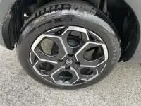 Gros plan sur la roue avant droite d'une Citroën C3 1.2 turbo noire, jante alliage au design hexagonal distinctif.