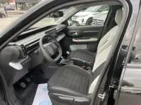 Intérieur de la Citroën C3 1.2 turbo 100 cv Max 2025 noir, vue côté conducteur avec tableau de bord et sièges en tissu visibles.