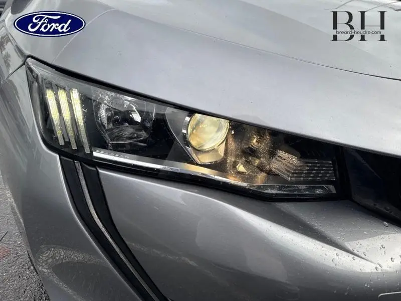 Gros plan sur le phare avant droit gris Platinium d’une Peugeot 508 SW 2020 avec signature lumineuse LED distinctive.