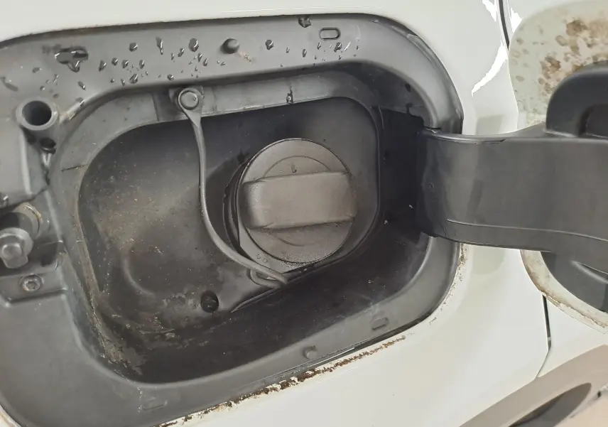 Gros plan sur l'ouverture de la trappe à carburant du Volkswagen T-Roc blanc pur avec toit noir, version essence 2022.