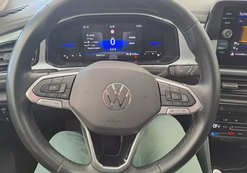 Vue centrée sur le volant noir du Volkswagen T-Roc 2022 avec tableau de bord numérique et commandes intégrées.
