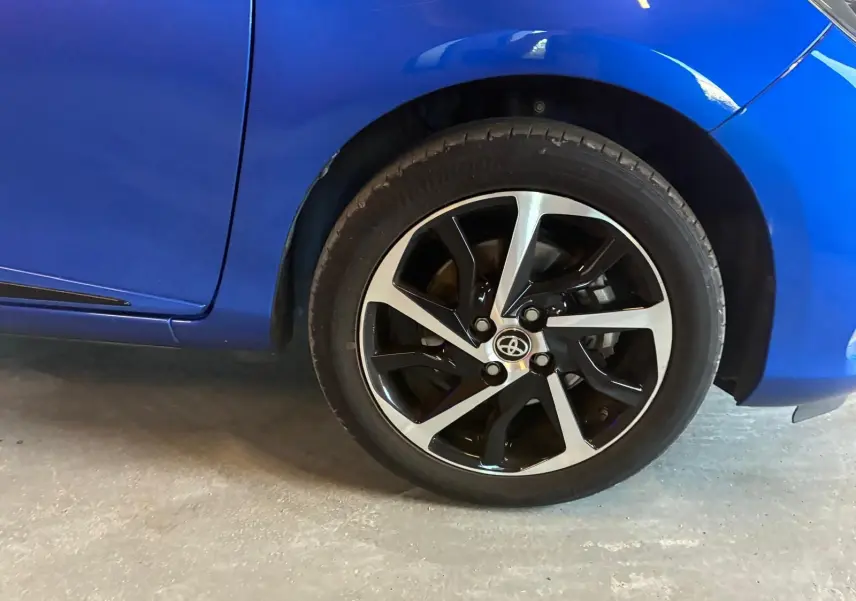 Gros plan sur la roue avant droite et la carrosserie bleue d'une Toyota Yaris 1.5 Hybrid Collection de 2020.