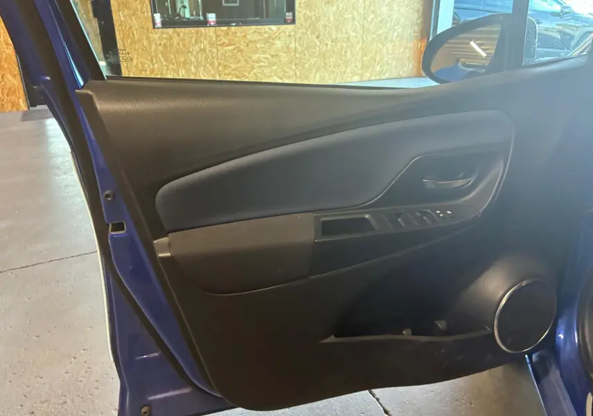 Vue intérieure de la porte avant droite bleu foncé de la Toyota Yaris 1.5 Hybrid Collection 2020 avec haut-parleur rond intégré.